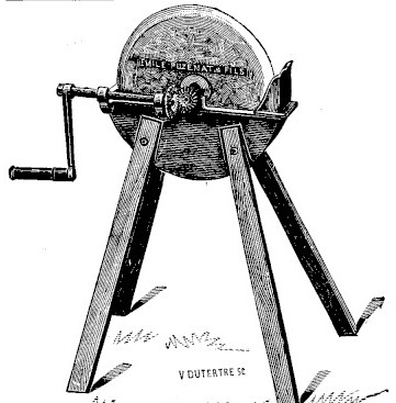Gravure&nbsp;: disque de grès monté sur un arbre horizontal, entraîné par un train d'engrenages et une manivelle à bras coudé&nbsp;; sous la meule, une auge oblongue&nbsp;; l'ensemble repose sur un bâti de trois montants de bois écartés